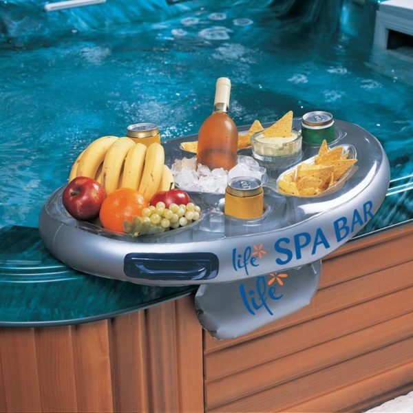 Inflatable bar sitting on edge of hot tub with food and drinks